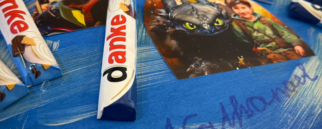 Ausschnitt einer selbstgebastelten Kollage; vorne angeschnittene Unterschrift Nathanael auf blauem Untergrund; dazu Fantasy-Fotos und aufgeklebte Schokoriegeln mit DANKE-Beschriftung