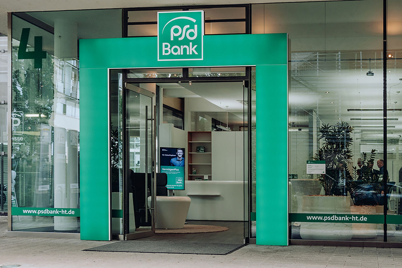 Eingangsbereich der Bankfiliale mit grünem Bogen und PSD Bank Logo