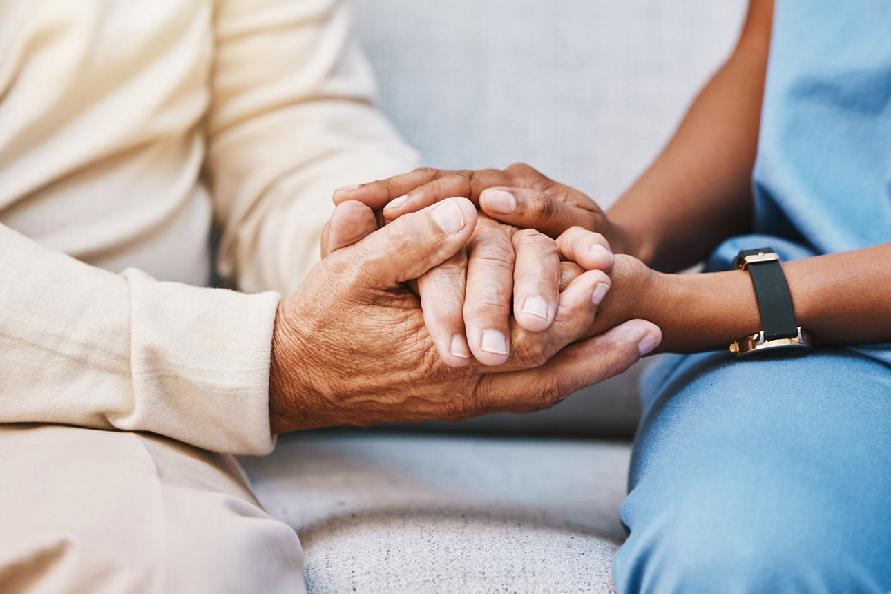 Zwei Personen halten sich unterstützend die Hand