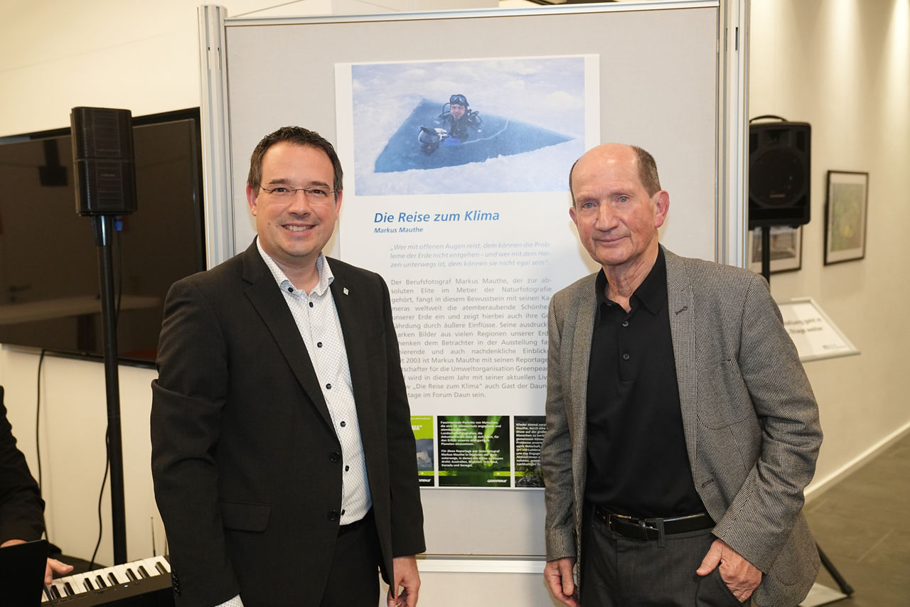 Zwei Personen stehen vor einer Fotoausstellung zusammen.