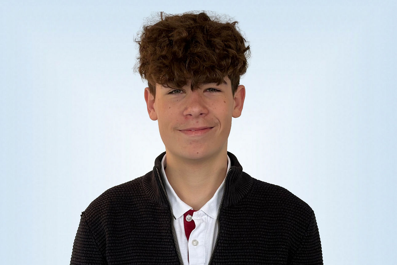 Praktikant Davin Slomian vor hellblauem Hintergrund