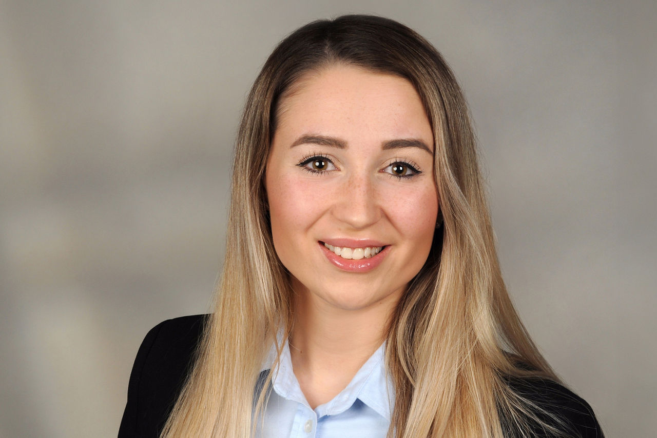 Chiara De Nuzzo hat braunblonde lange Haare und trägt eine hellblaue Bluse mit einem schwarzen Blazer.