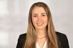 Chiara De Nuzzo hat braunblonde lange Haare und trägt eine hellblaue Bluse mit einem schwarzen Blazer.