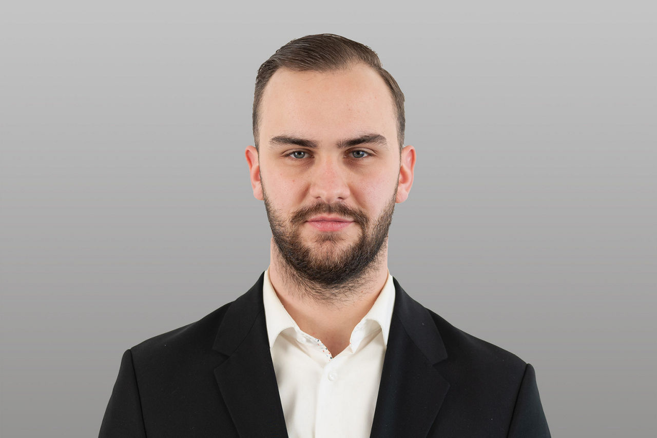 Kundenberater Tim Deitermann vor grauen Hintergrund