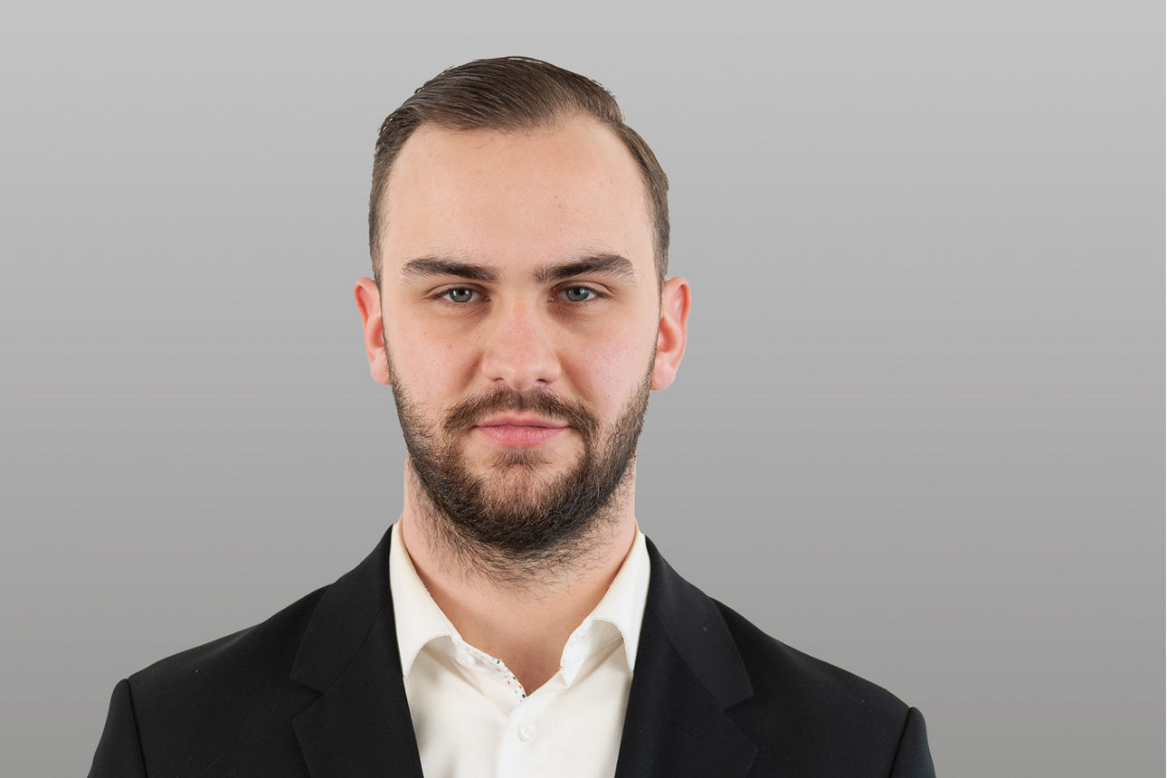 Kundenberater Tim Deitermann vor grauen Hintergrund