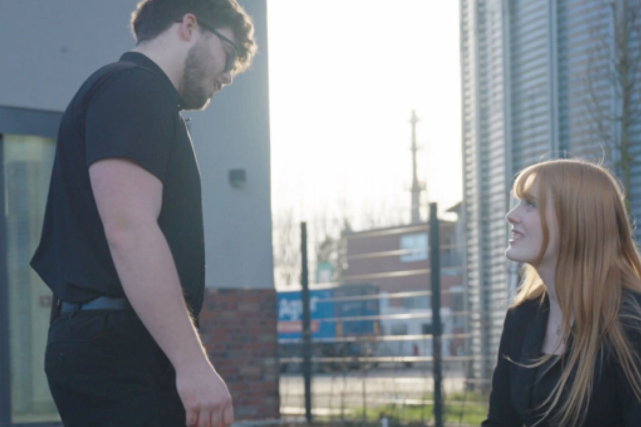 Ein junger Mann mit einer jungen Frau die eine Unterhaltung führen. 