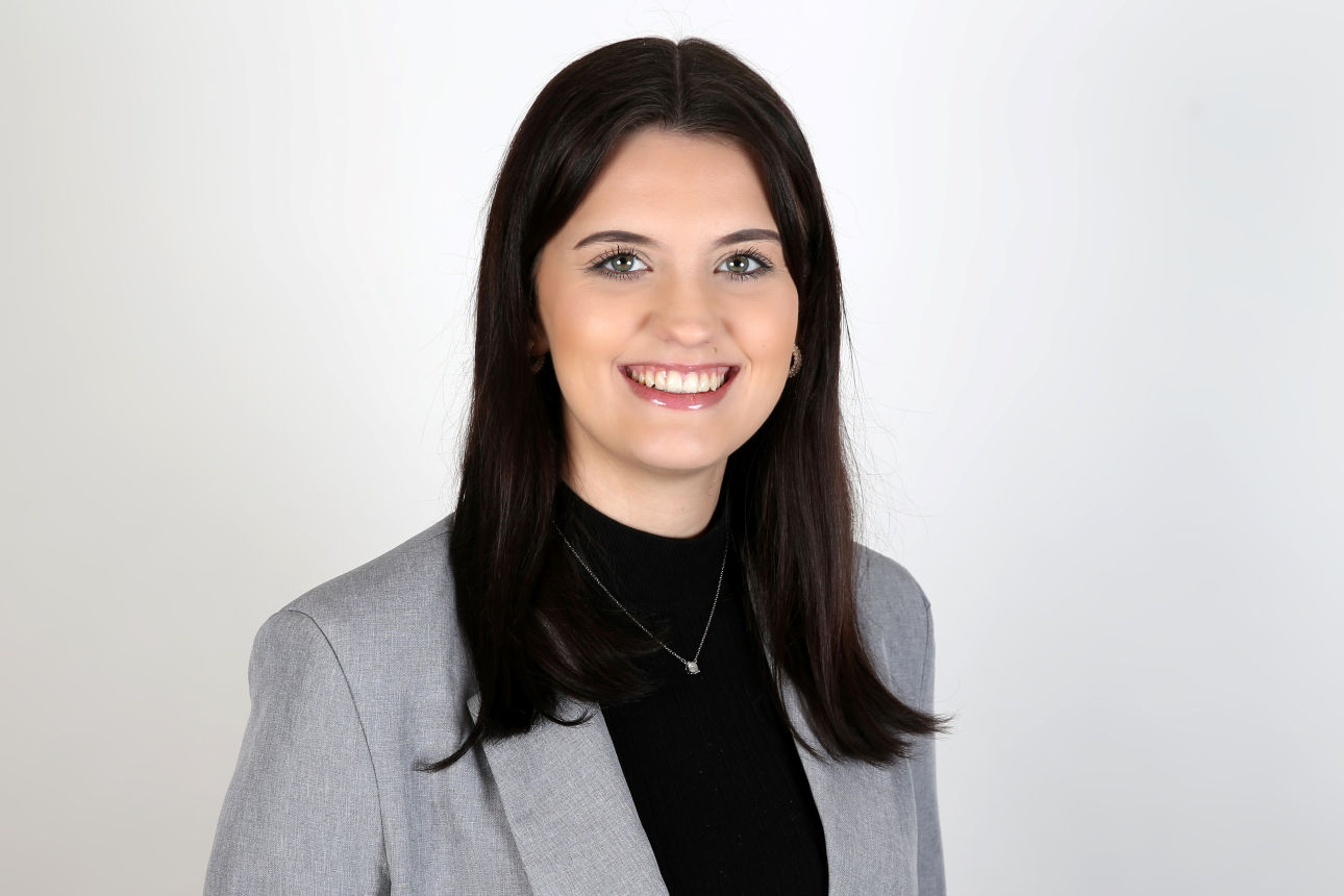 Eine lächelnde Frau schaut in die Kamera.