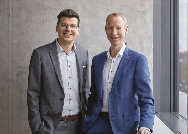 Zwei elegant gekleidete Männer lächeln