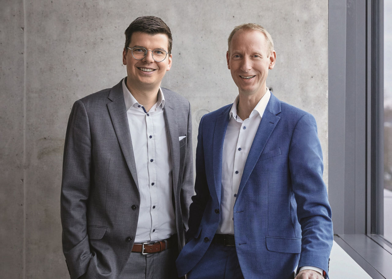 Zwei elegant gekleidete Männer lächelnd