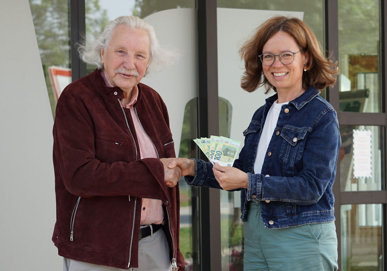 Herr Peter Diefenbach hat in der Juni Ziehung beim Gewinnsparen 500 Euro gewonnen und erhält von Katharina Stumbaum seinen Gewinn.