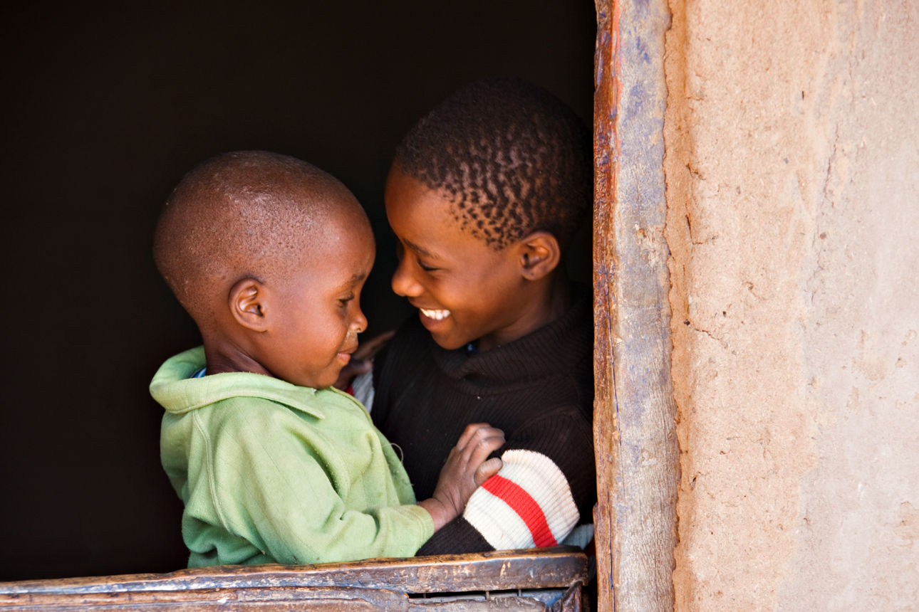 Zwei afrikanische Jungen lachen sich an