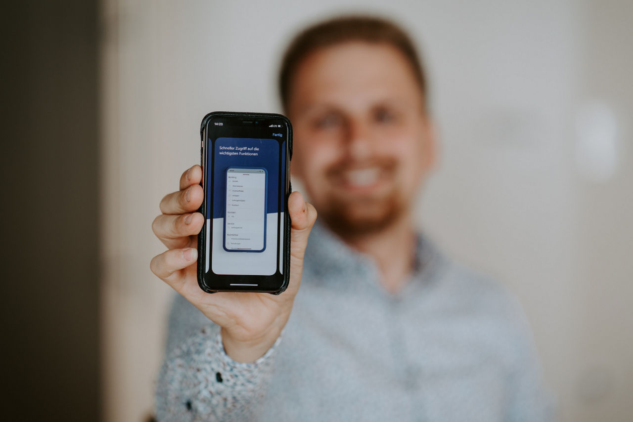 Ein Mann hält ein Smartphone in die Kamera