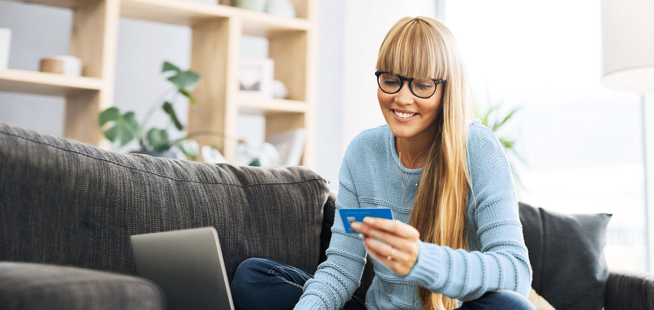 Frau hält eine Mastercard DirectCard in der Hand
