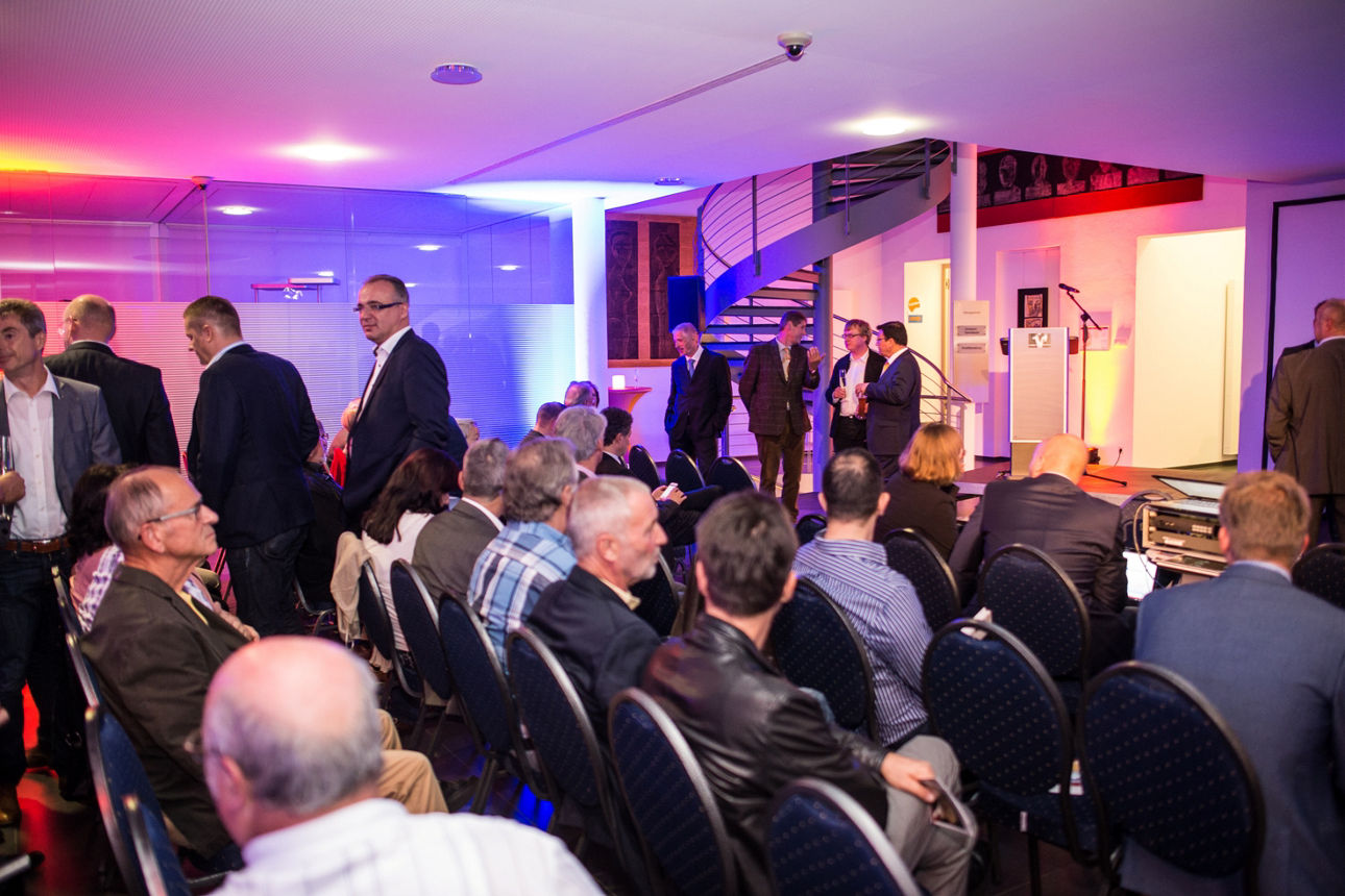 festliche Stimmung, gespanntes Publikum auf Stuhlreihen bei der Eröffnungsfeier