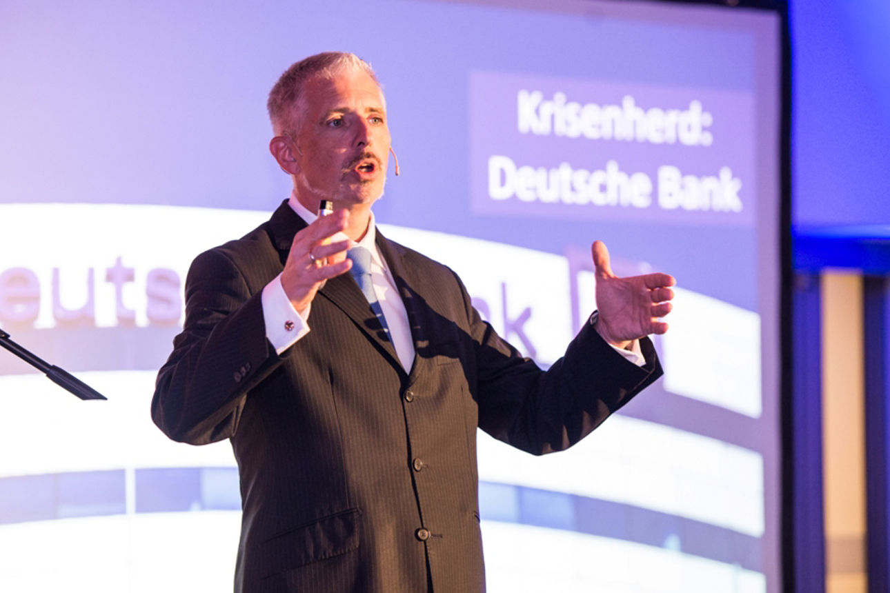 Börsenexperte Dirk Müller gestikuliert auf der Bühne bei seinem Vortrag