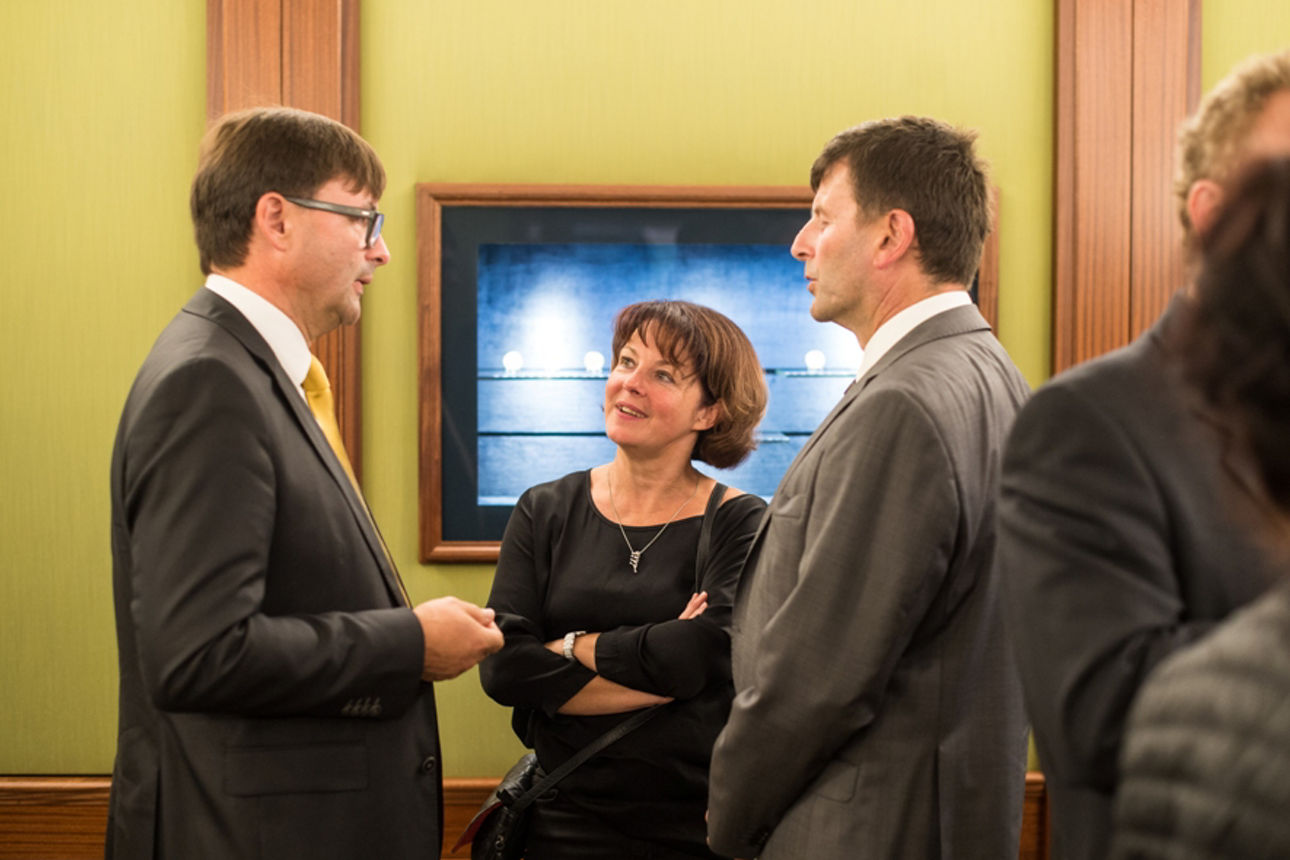 Drei Personen in der Gold•Welt im angeregten Gespräch