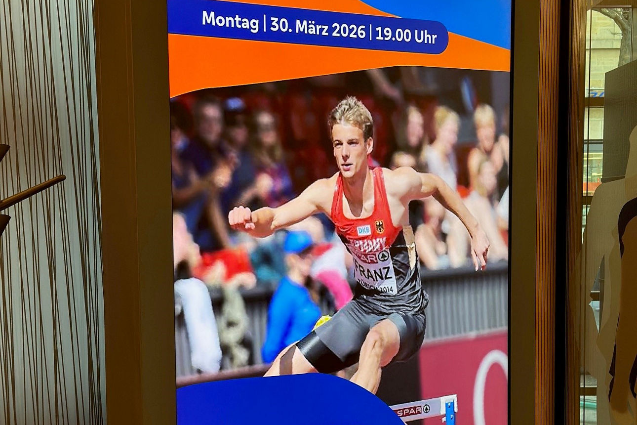 Ankündigung des Vortrags von Felix Franz auf einem Display in der Filiale