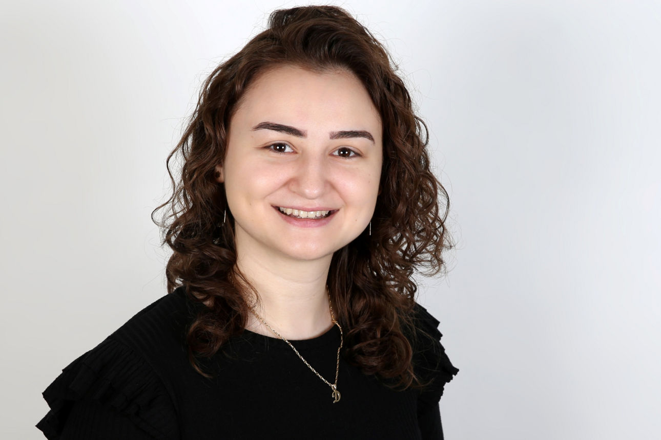 Eine lächelnde Frau schaut in die Kamera.