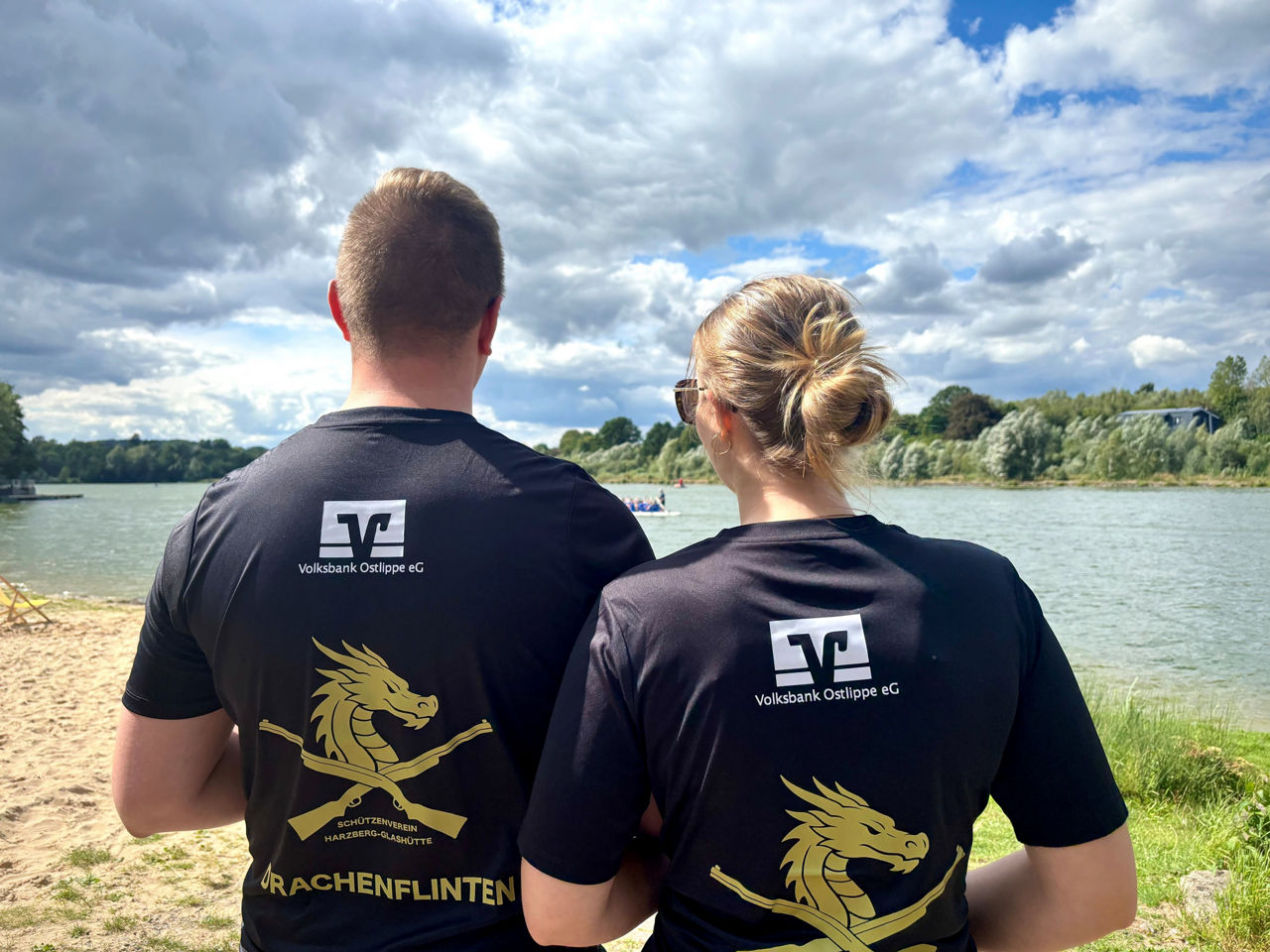 Zwei Personen der Drachenbootregatta SchiederSee in der Rückansicht, das Logo der Volksbank auf den Shirts erkennbar