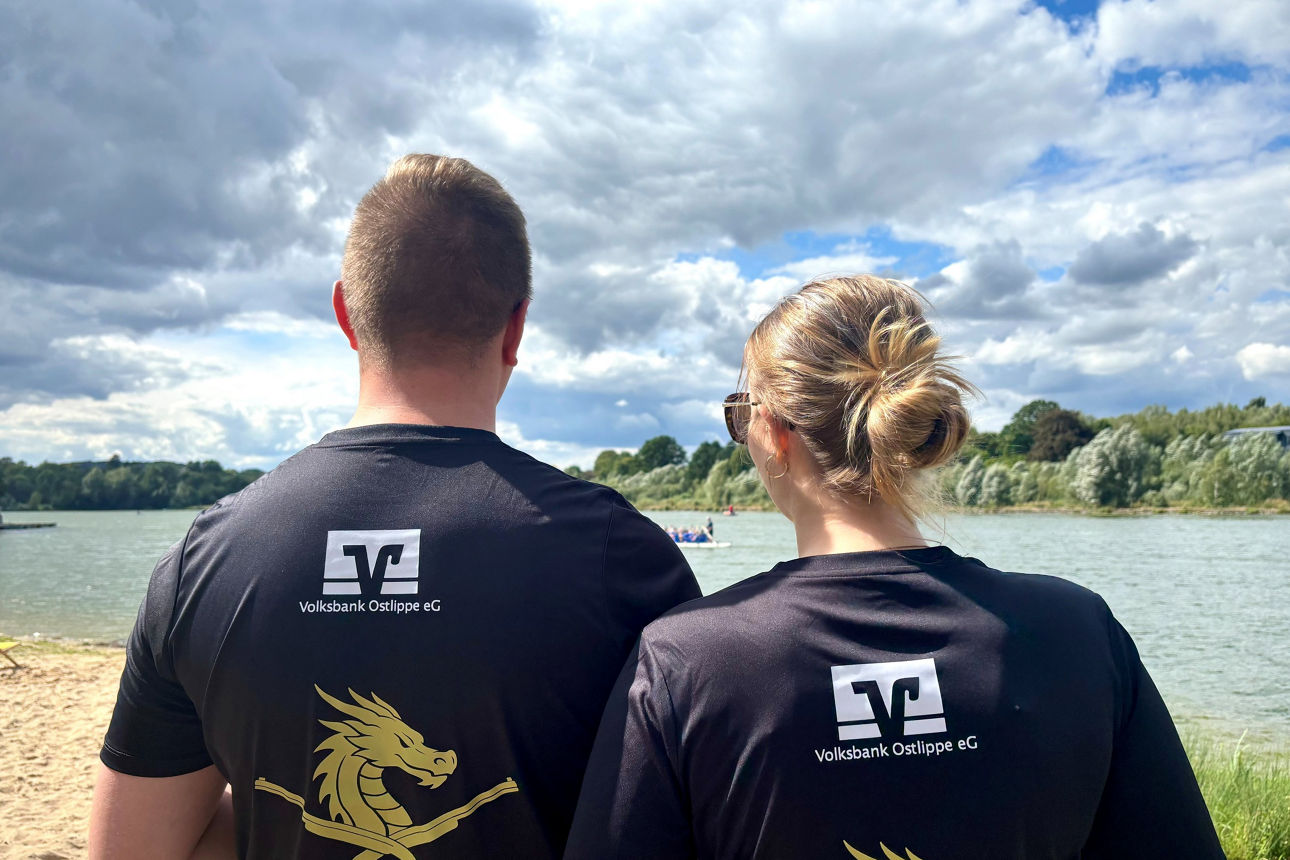 Zwei Personen der Drachenbootregatta SchiederSee in der Rückansicht, das Logo der Volksbank auf den Shirts erkennbar