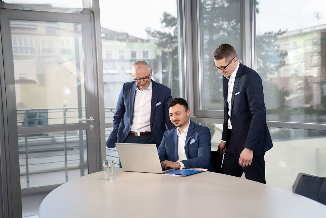 Die Firmenkundenberater Harald Hoch, Kay Ebitsch und Martin Haubner schauen gemeinsam in einen Laptop
