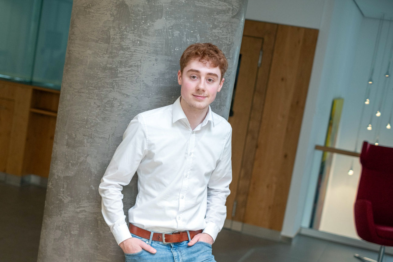 Junger Mann lehnt an einer Säule an