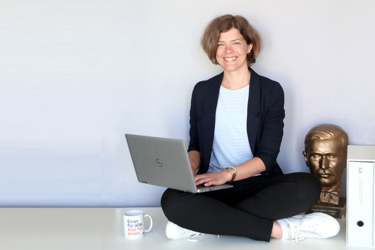 Junge Frau im Schneidersitz mit Notebook