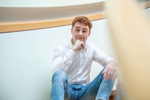 Junger Mann sitzt auf einer Treppe