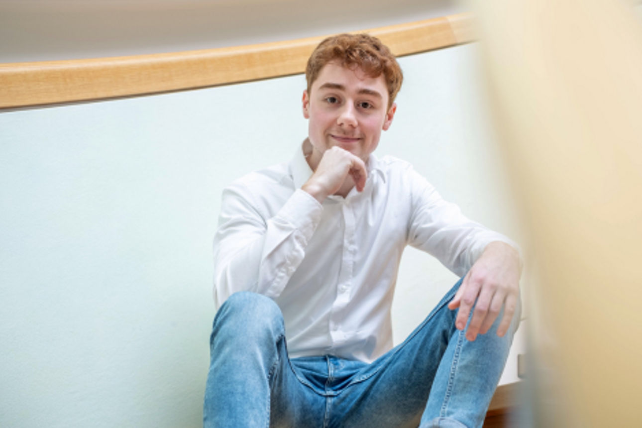 Junger Mann sitzt auf einer Treppe