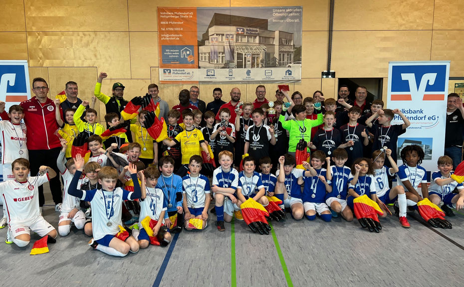 Eine Gruppe von Kindern in Sportkleidung mit Medaillen und Pokalen in der Hand