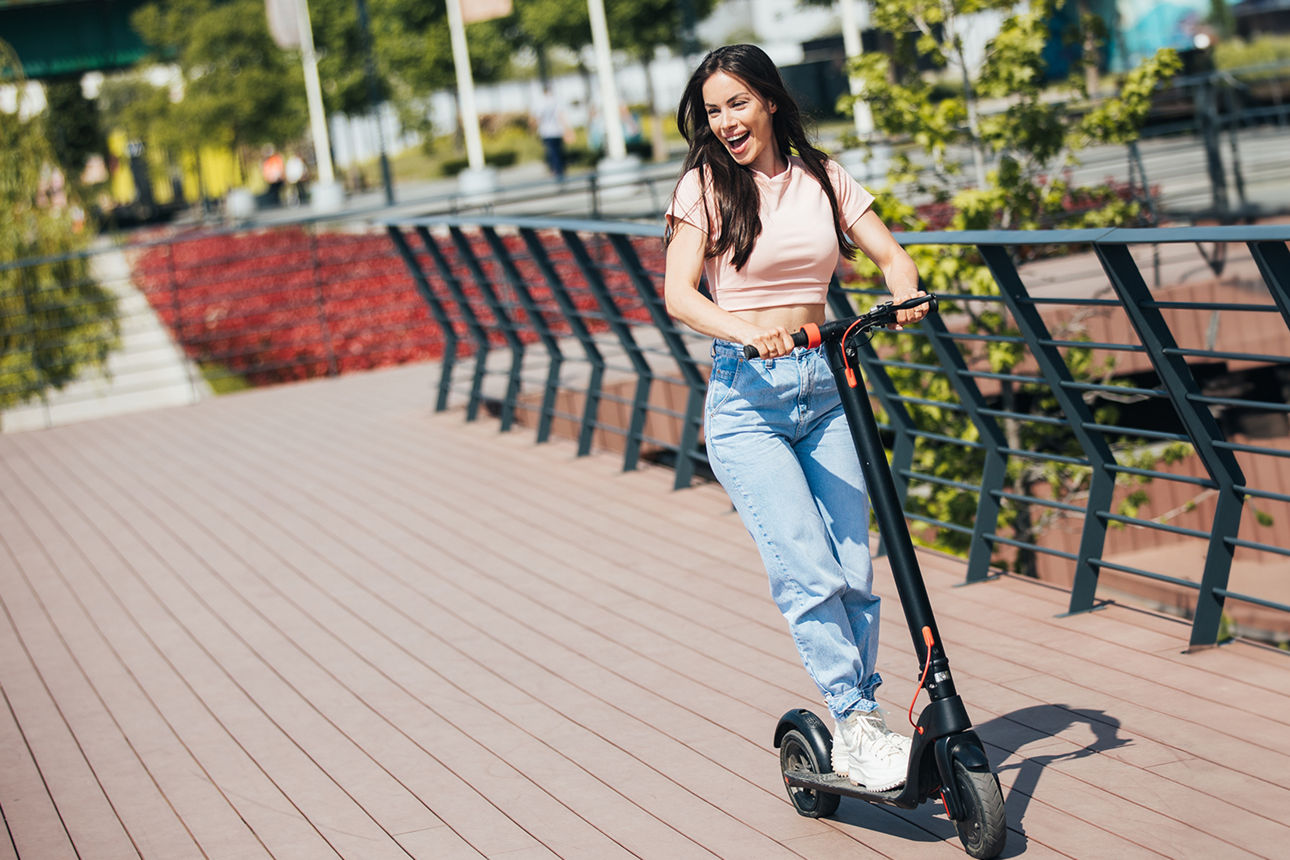junge Frau fährt E-Scooter