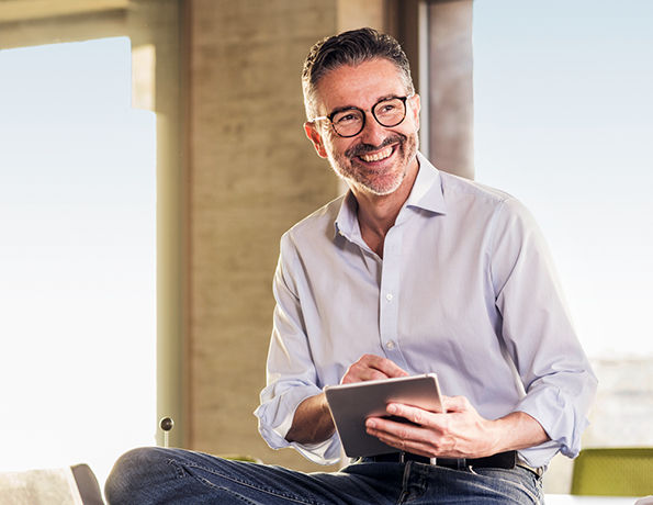 EDEKA-Depot Premium Mann lacht und tippt auf Tablet