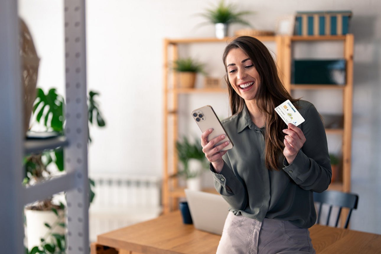 EDEKA-Konto - Frau hält ein Smartphone und die girocard in den Händen