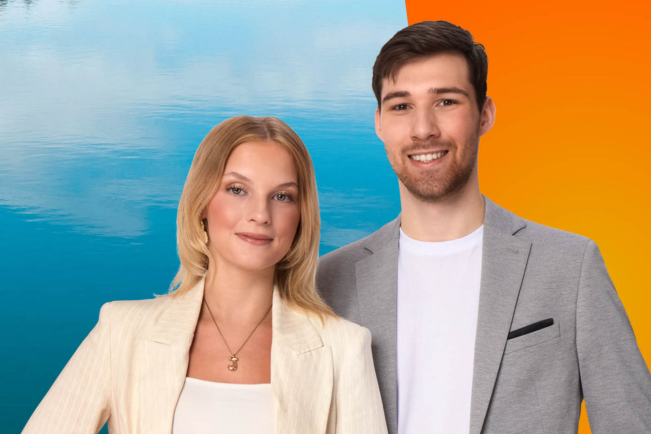 Zwei junge Azubis stehen vor orangem/blauem Hintergrund