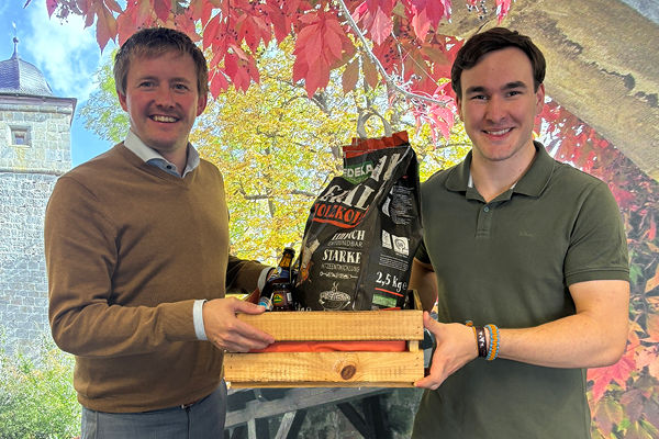 Unser Kunde Benedikt Marks bekommt das erste Grillpaket von Kundenbetreuer Benjamin Lutz überreicht