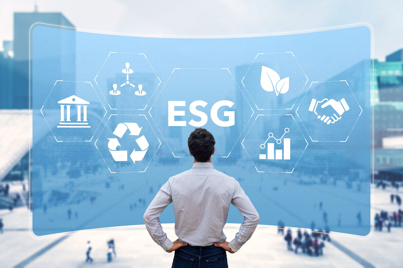 Person steht vor digitalem ESG-Display mit Symbolen zu Umwelt, Soziales und Führung
