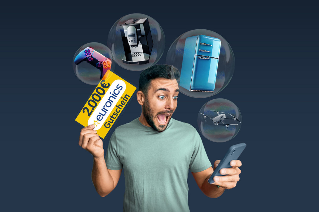 Junger Mann hält gelben Gutschein mit Aufschrift '2.000€ euronics Gutschein' und eine bunte Spielkonsole in der Hand. Rechts 