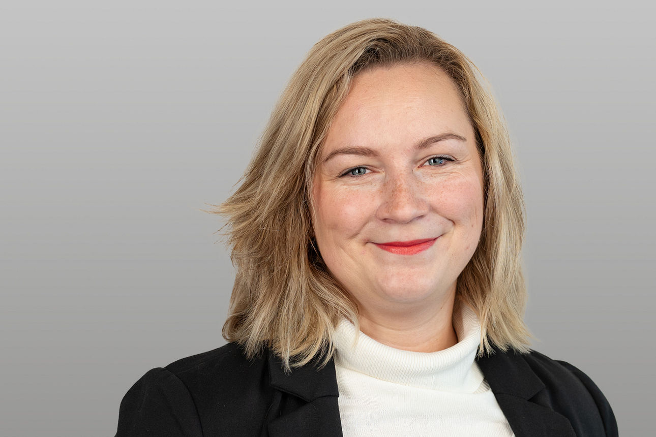 Privatkundenberaterin Carina Eckhardt-Gunst vor grauen Hintergrund
