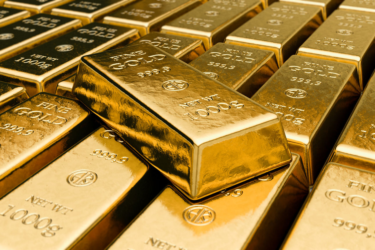 Mehrere Goldbarren in einer Reihe, einer liegt oben drauf