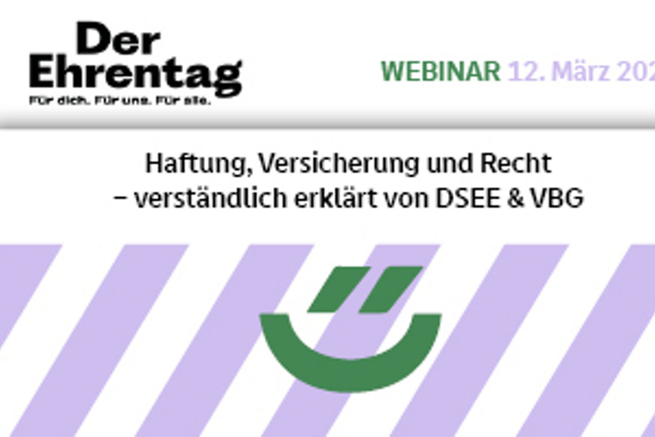 Junger Mann sitzt am Laptop und hält ein Smartphone in der Hand