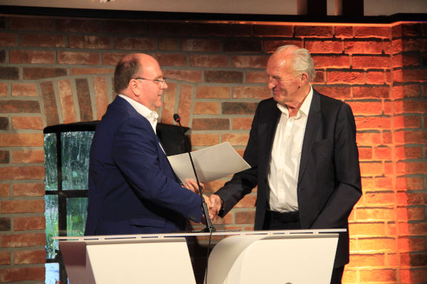 Carsten Waldhelm schüttelt Johannes Böckenhoff die Hand, während er auf einer Kanzel steht