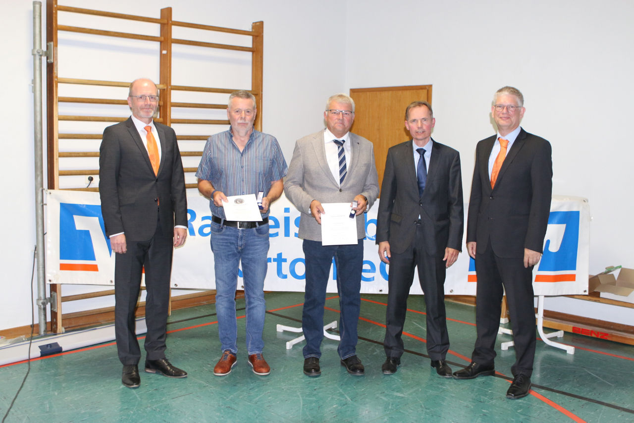 Gruppe von Männern, die in einer Sporthalle Auszeichnungen erhalten.