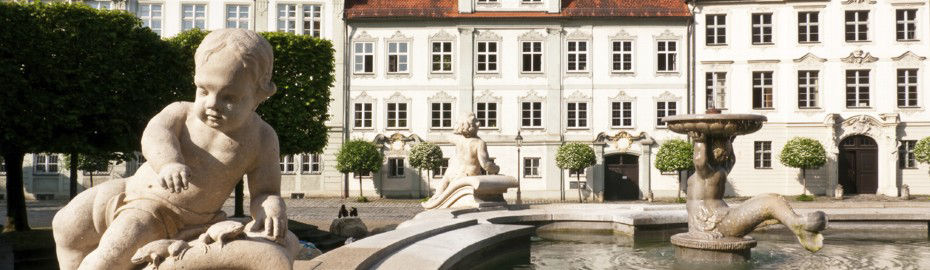 Historisches Gebäude davor ein Brunnen 