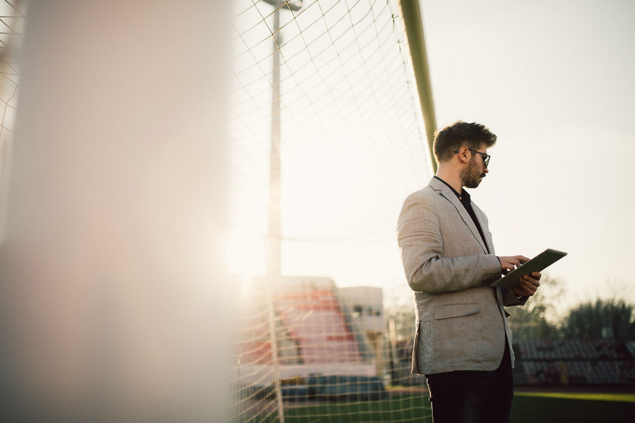 Mann in leerem Tor mit Tablet in der Hand
