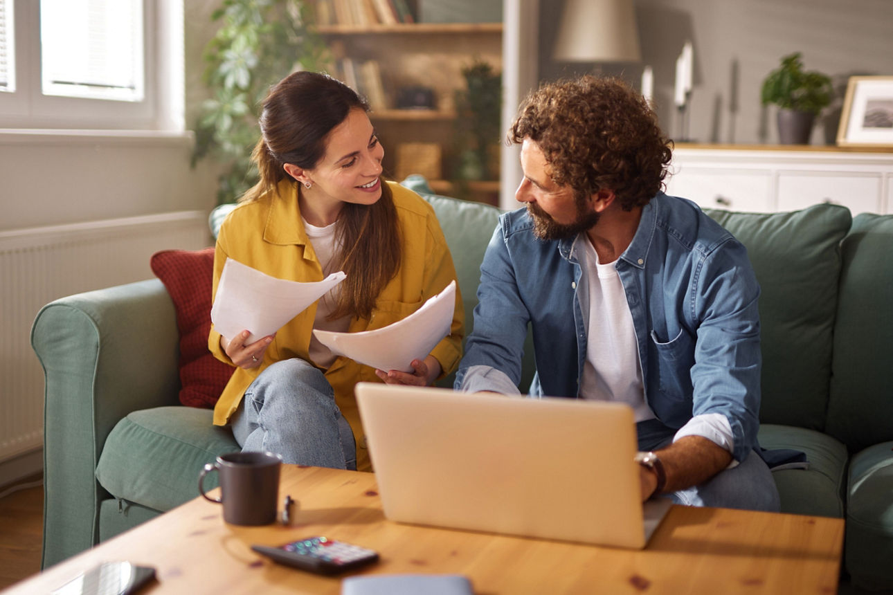 Mann mit kleinem Kind auf seinem Schoß arbeitet am Laptop