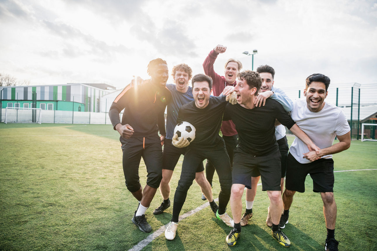 Gruppe junger Männer feiern auf dem Fußballplatz