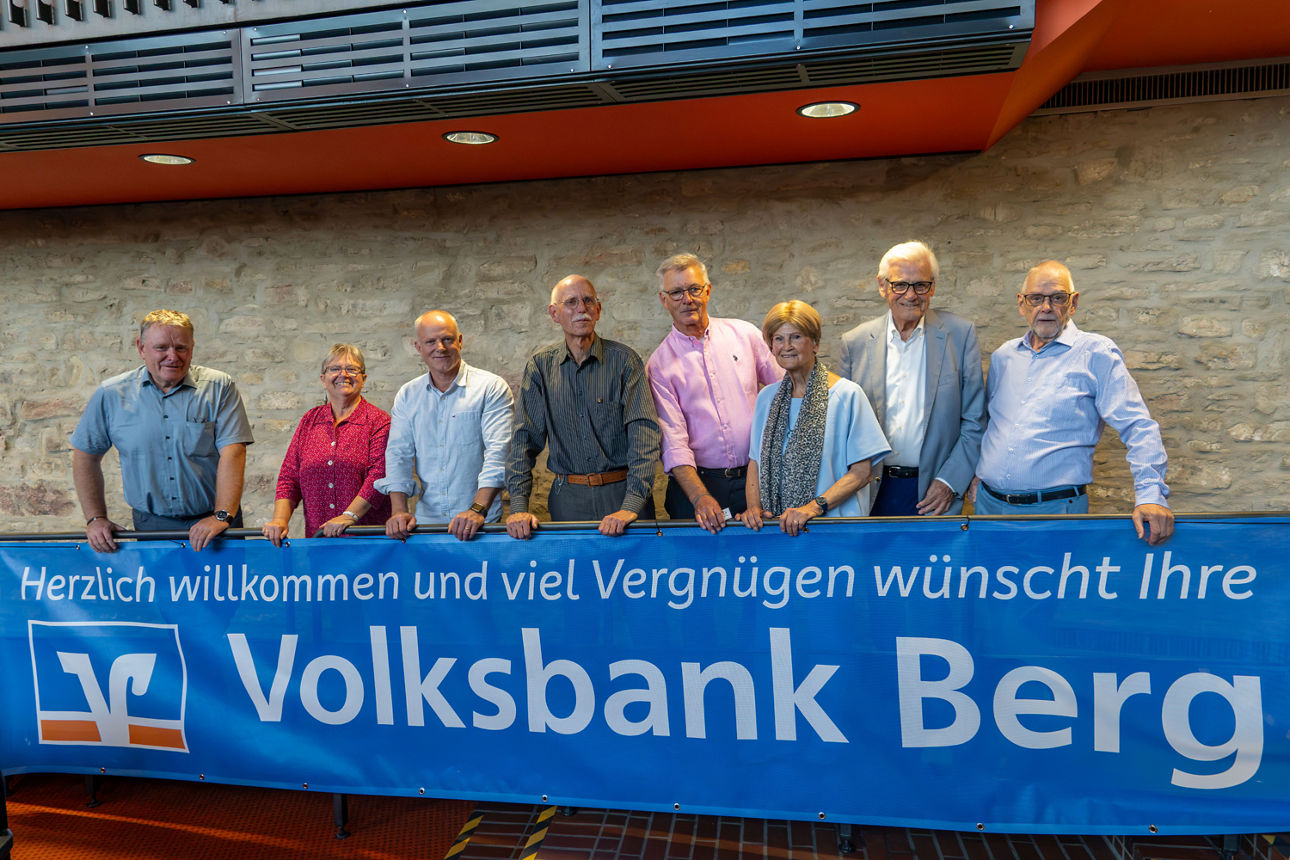 Mehrere Personen stehen hinter einem Banner der Volksbank Berg und lächeln in die Kamera.