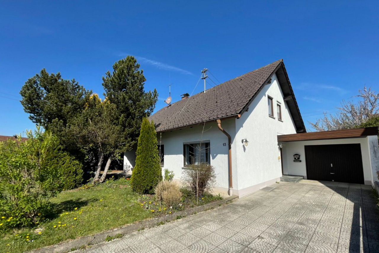 Außenansicht eines Einfamiliennhauses mit Garten und Garage