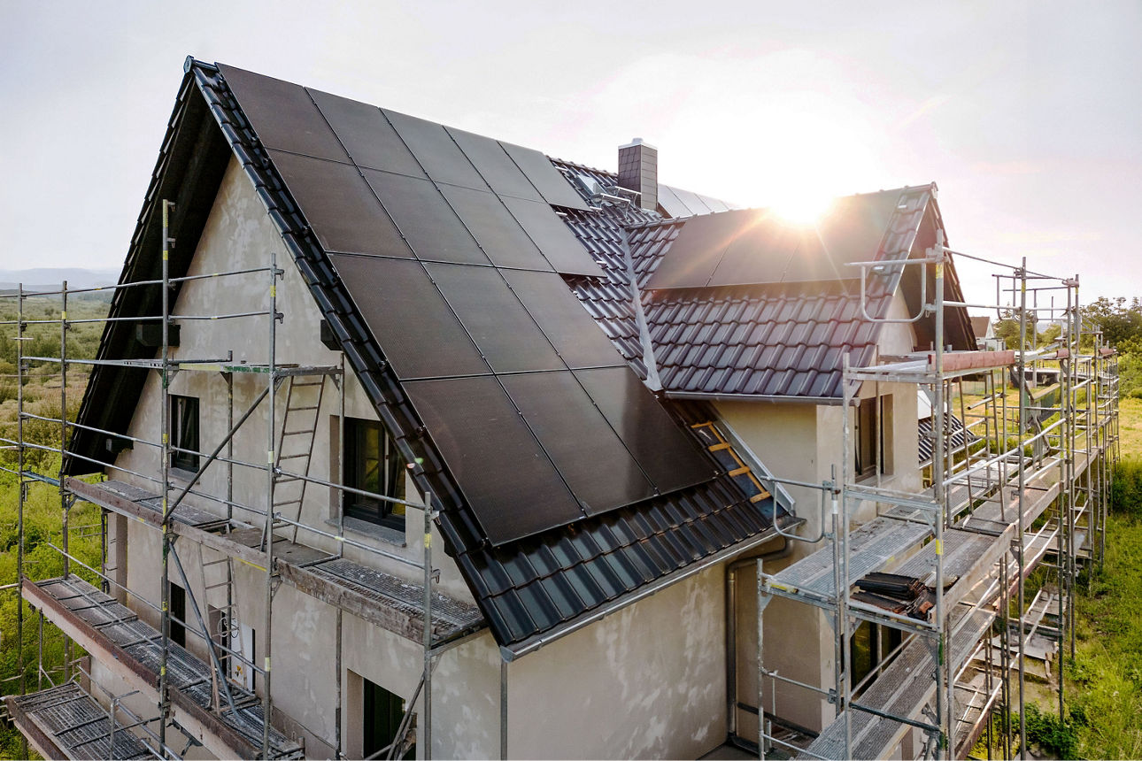 Eingerüstetes Haus mit PV-Anlage und neuer Fassade