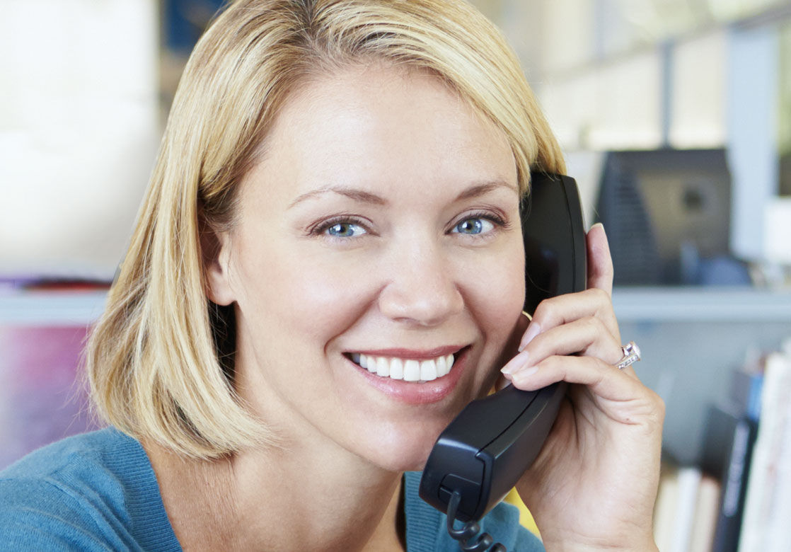 Frau mit einem Telefonhörer am Ohr